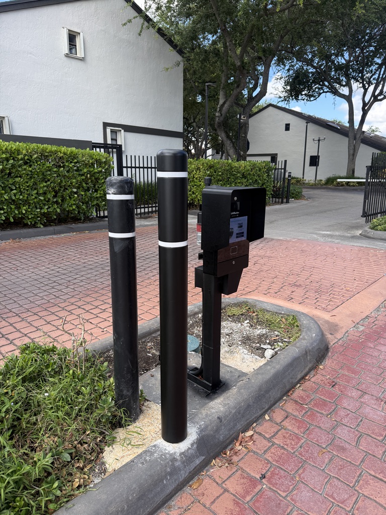 Community entrance callbox protected by three black bollards