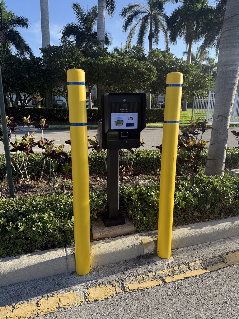 Completed black callbox protected by two bright yellow bollards