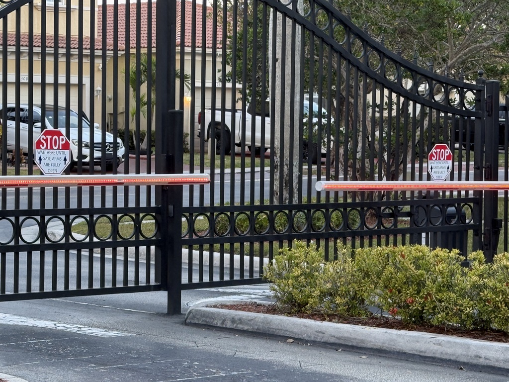 Black dual swing gates fitted with illuminated red safety arms