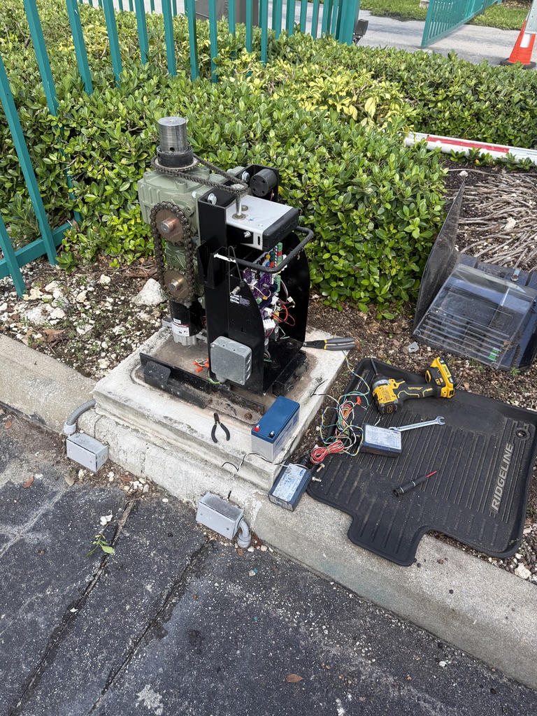 Open gate operator with tools and testing equipment during a field repair