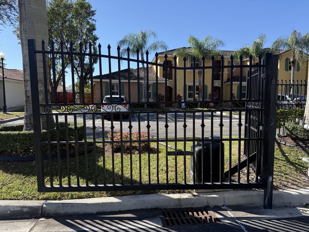 Black ornamental swing gate with operator at a residential community